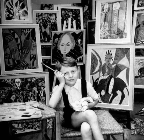 Hasan Kaptan, un niño prodigio turco de nueve años, se sienta orgulloso frente a su trabajo para una exposición en una galería de París.