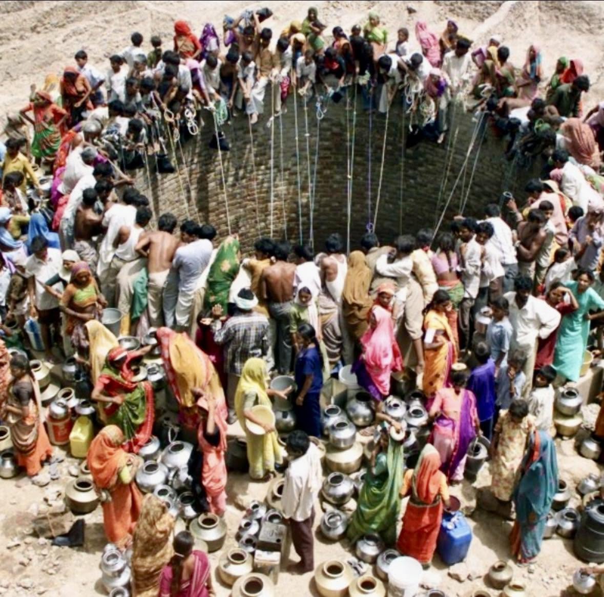 En la imagen se ve un grupo de personas que se reúne en el pueblo de Natwargadh, en Gujarat, India, para obtener agua de un pozo
