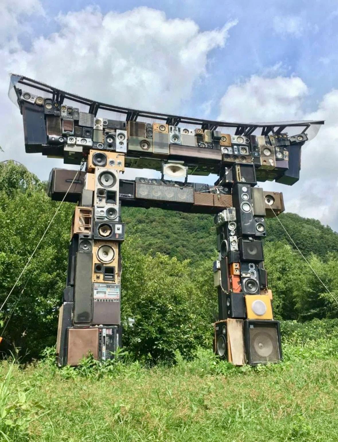 Imagina una estructura de 300 altavoces reciclados, cables y circuitos, alzándose en medio de Tokio con la forma imponente de un arco Torii